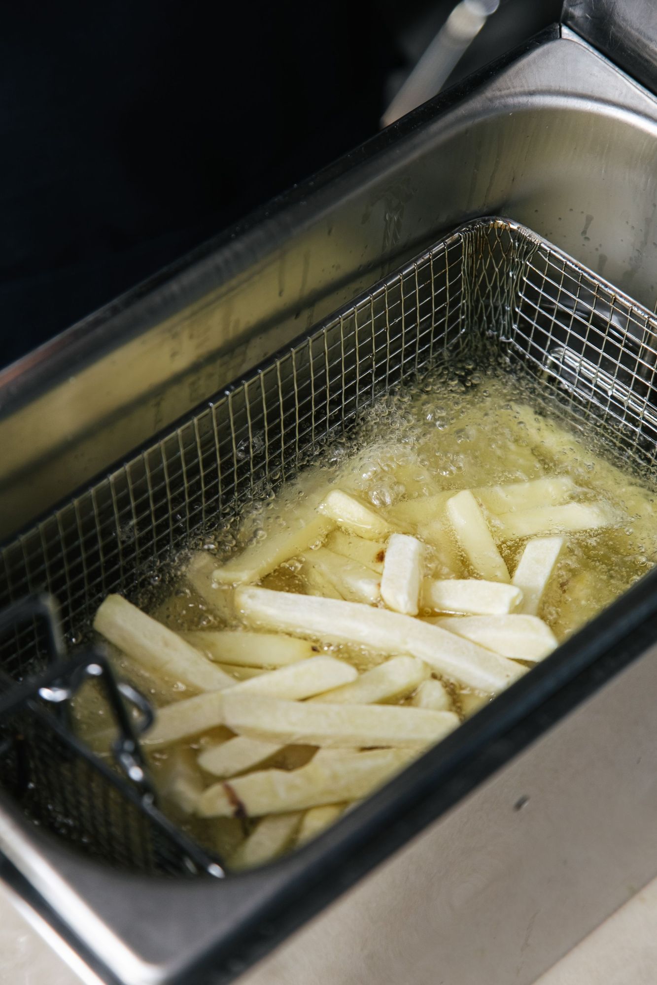 Frites crues plongées dans l'huile