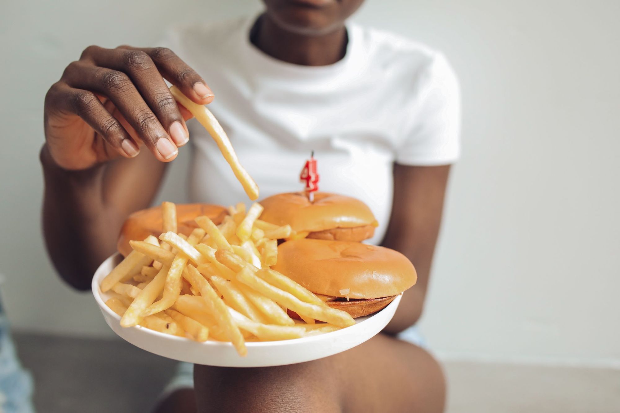Personne savourant une assiette de frites et un burger