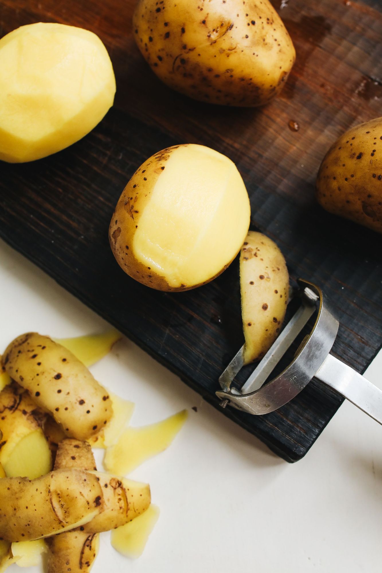 Pommes de terre lavées et épluchées sur une planche